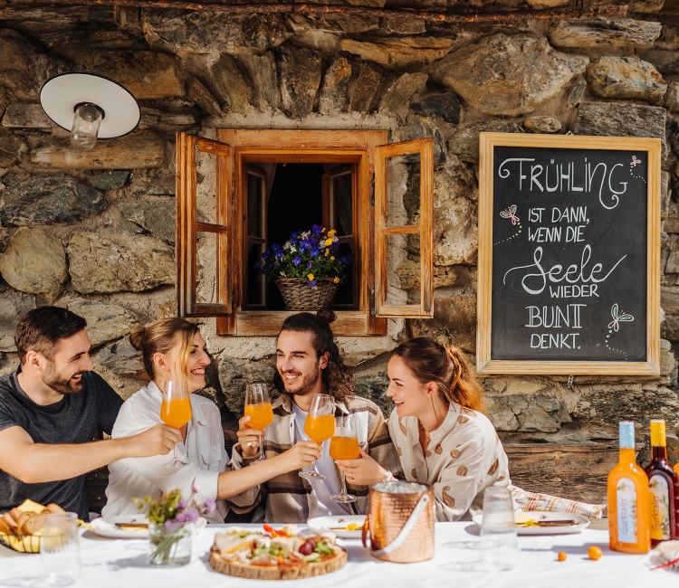 Freunde trinken Gurktaler Alpen-Aperitif auf einer Almhütte