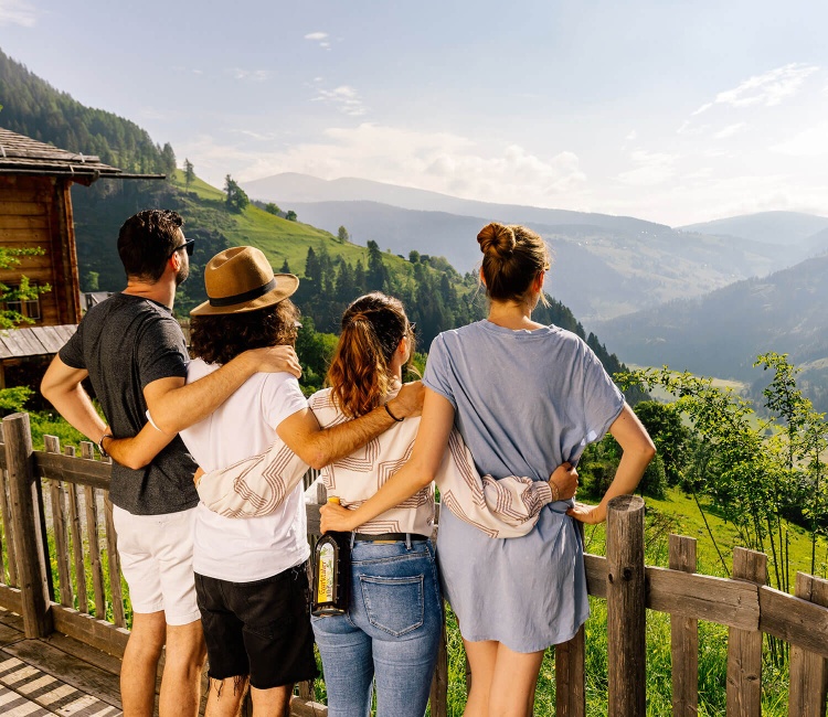 Vier Freunde genießen den Ausblick stehts mit Gurktaler Alpenkräuter